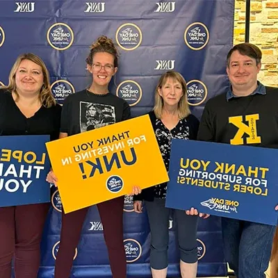 alumni and professors pose for a photo